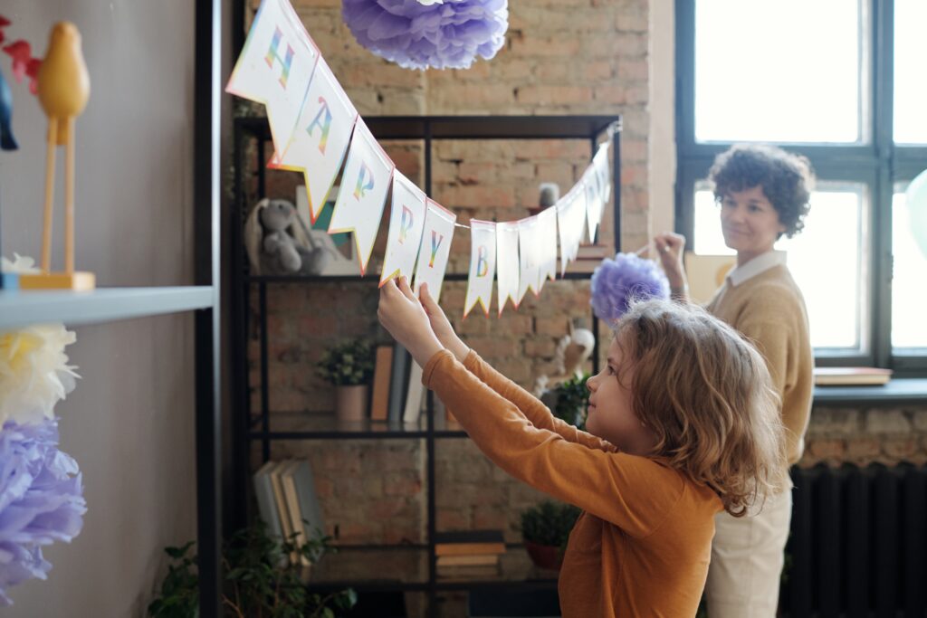 Why Kylie Kelce refuses to give ‘sibling gifts’ and 10 alternatives for parents who agree | "I am vehemently against the idea of other kids getting birthday presents on a child's birthday.” Pregnancy News son helping mother prepare for birthday party