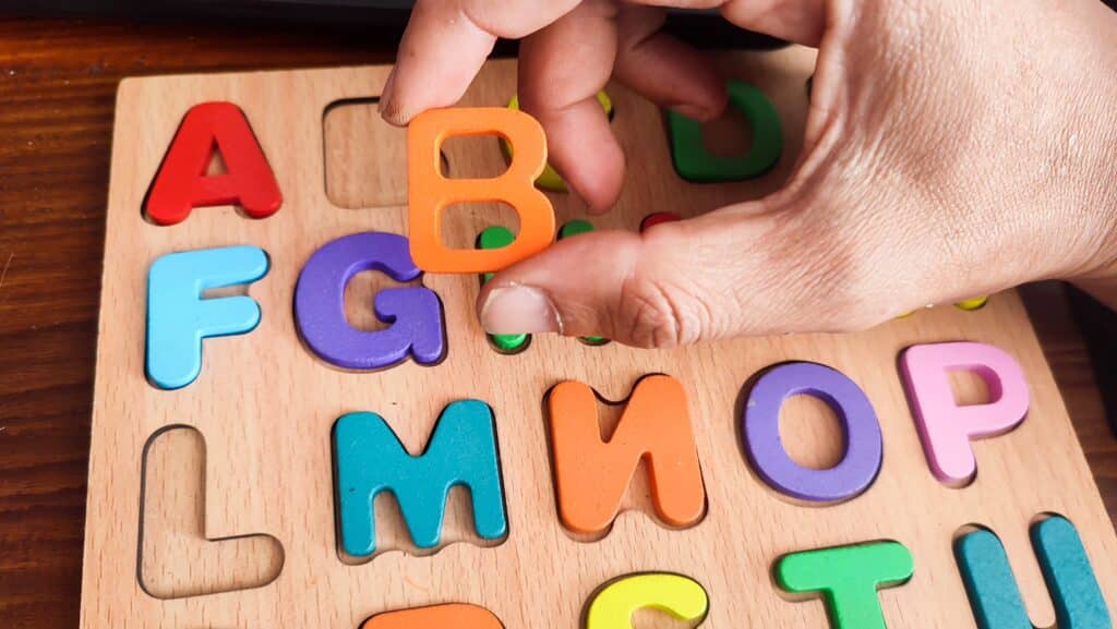 50+ B Boy Names to Consider for Your Son | We’re seeing a new generation of B boy names emerge in the United States today. Baby Names parent holding letter b alphabet block