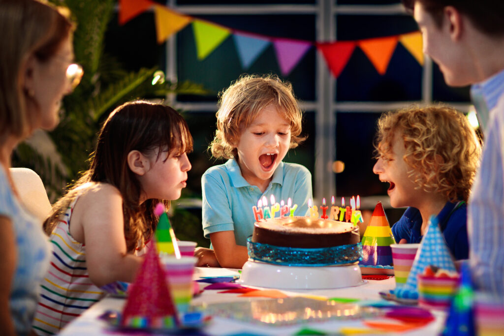 Why Kylie Kelce refuses to give ‘sibling gifts’ and 10 alternatives for parents who agree | "I am vehemently against the idea of other kids getting birthday presents on a child's birthday.” Pregnancy News kids eating birthday cake blowing out candles