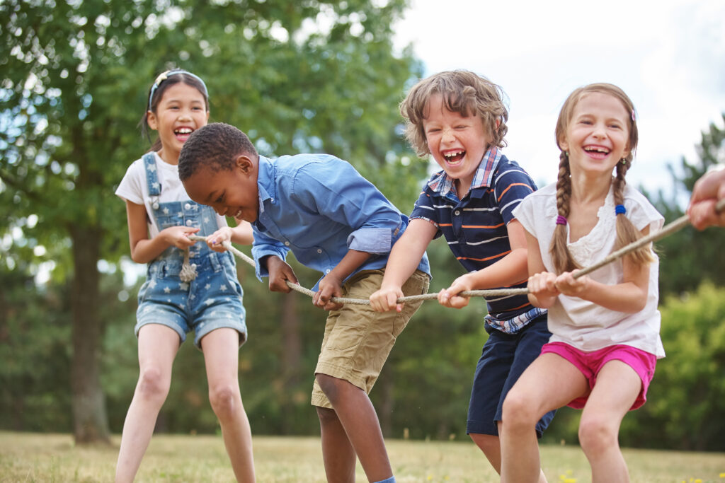 Why Kylie Kelce refuses to give ‘sibling gifts’ and 10 alternatives for parents who agree | "I am vehemently against the idea of other kids getting birthday presents on a child's birthday.” Pregnancy News kids playing tug of war