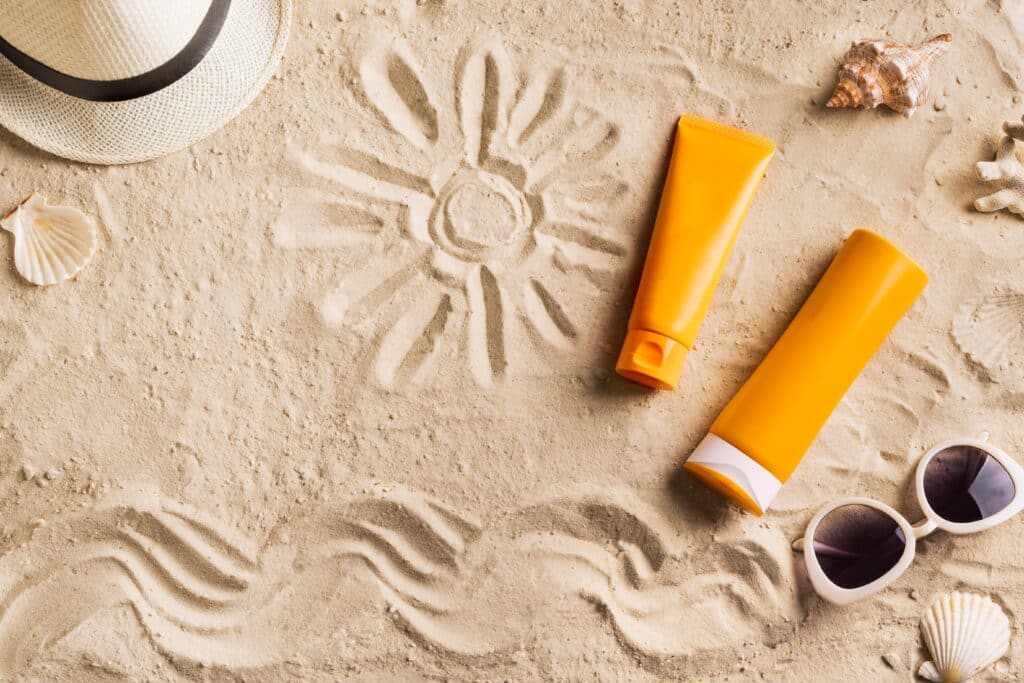 It’s National Sunscreen Day: Here’s how you can protect your skin this summer | May 27 is National Sunscreen Day! News sunscreen glasses hat on beach sand