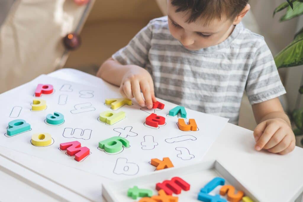 young boy playing with alphabet letters