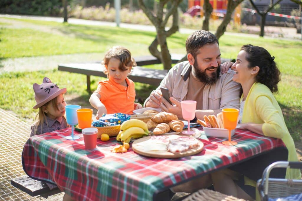 family eats food at picnic table
