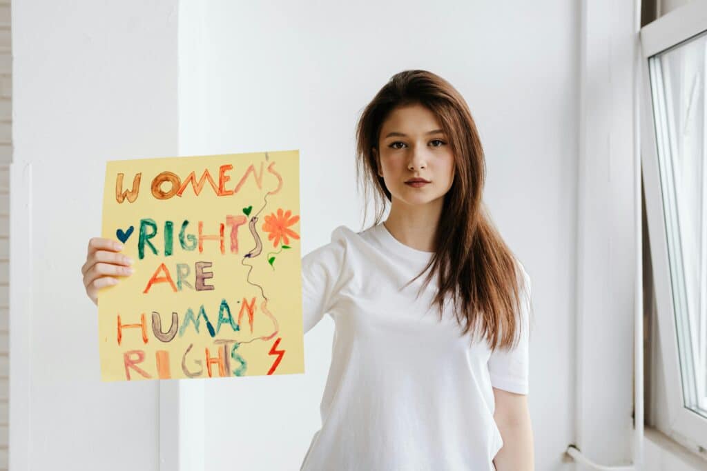 Celebrate Women’s Equality Day with these strong girl names inspired by women’s rights activists | Baby name inspiration is all around us — especially on a day as meaningful as Women’s Equality Day. Babies women's rights activist holding sign for women's equality day