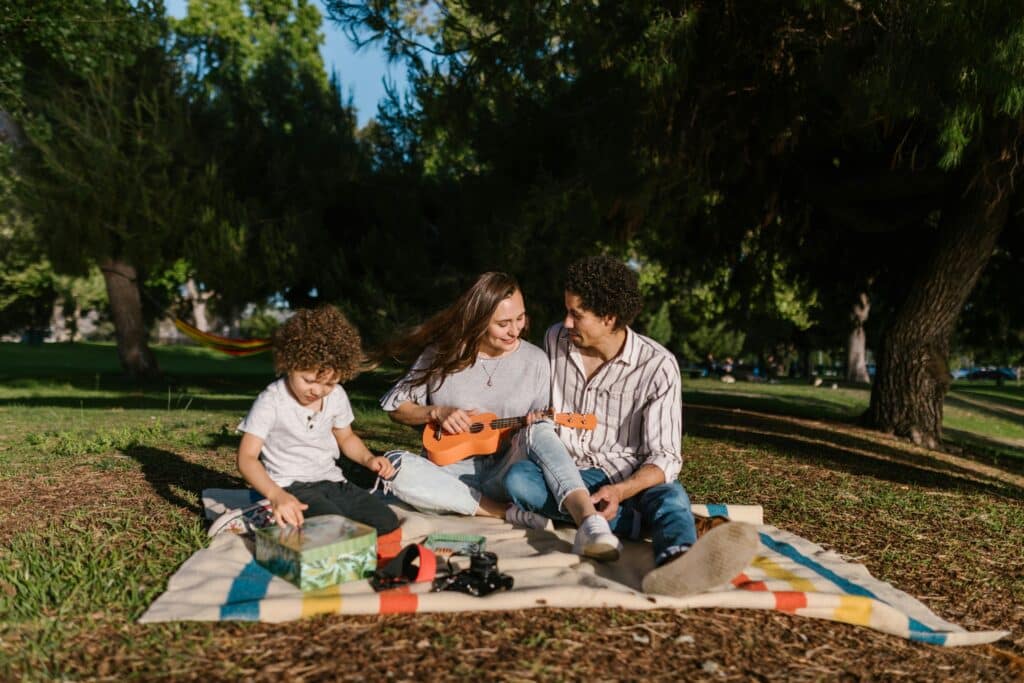 Adorable family picnic food ideas to celebrate National Eat Outside Day | National Eat Outside Day is almost here — and it’s the perfect excuse to round up the family for a picnic. Food family having picnic on blanket outside