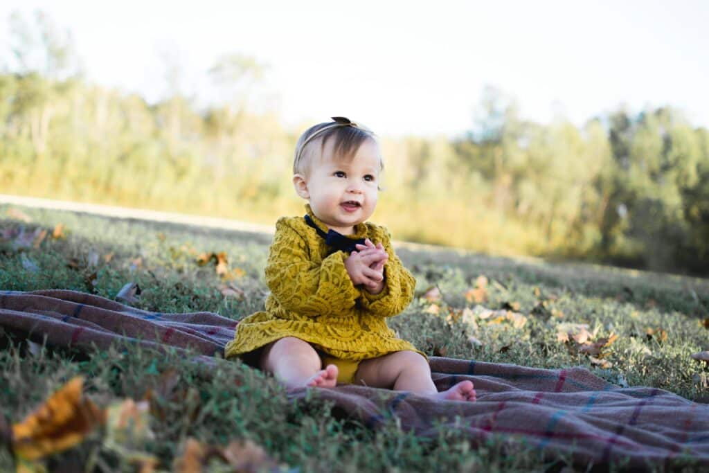 baby girl on grass during fall season