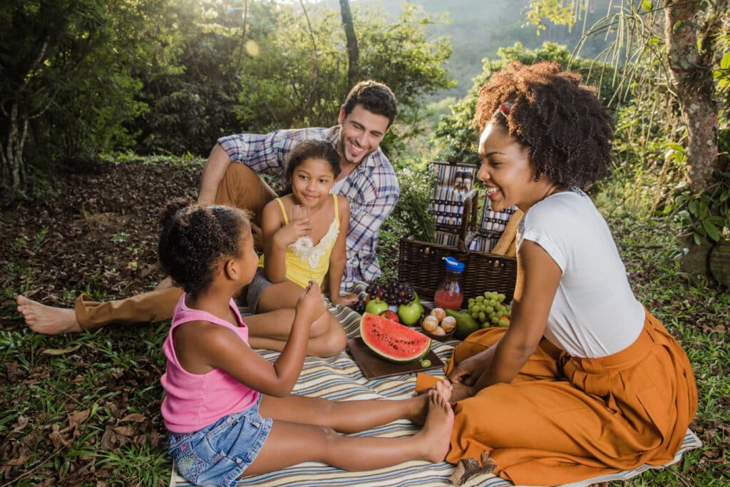 Adorable family picnic food ideas to celebrate National Eat Outside Day | National Eat Outside Day is almost here — and it’s the perfect excuse to round up the family for a picnic. Food family with two kids enjoying outdoor picnic