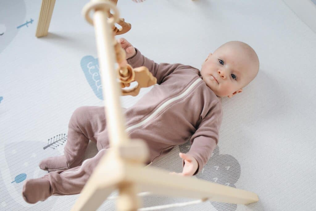 baby staring up at camera while laying in crib
