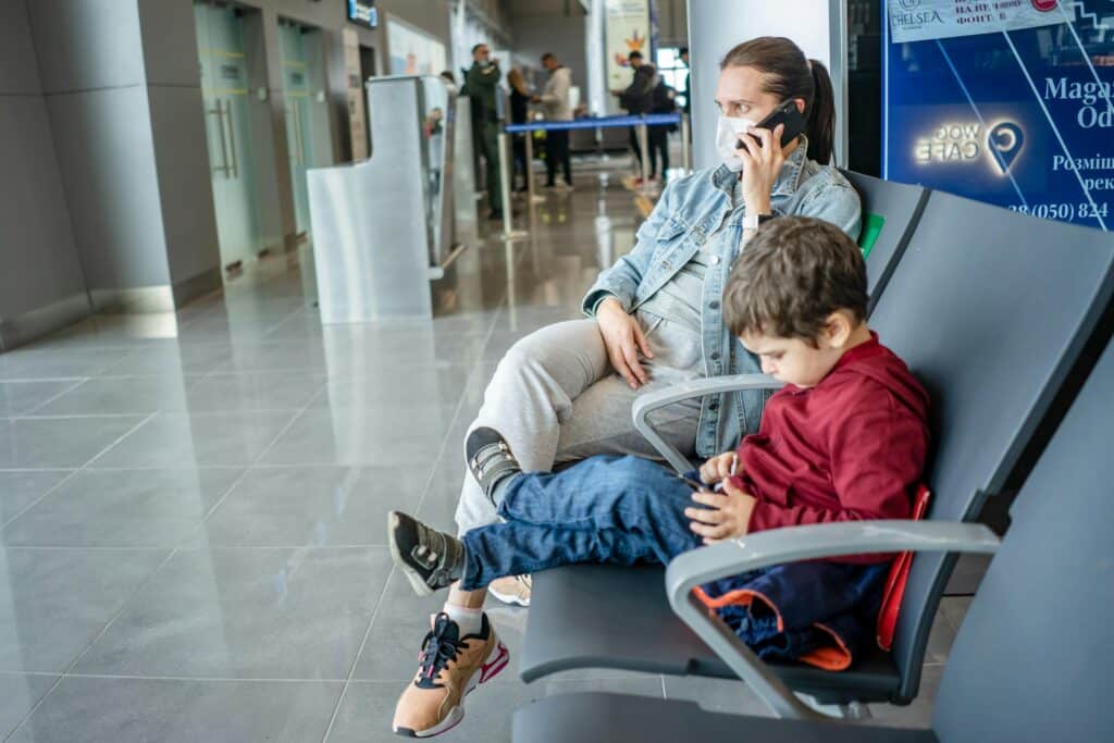 mom and son sitting in airport delta skymiles