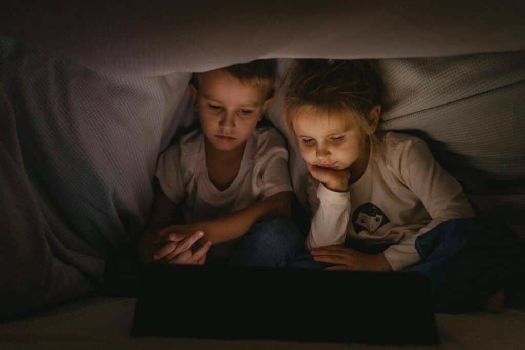 screen time for kids boy and girl in bed tablet