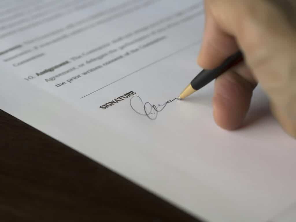 person writing signature on legal paperwork birthday wish